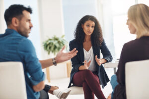 Group discussion among three individuals, focusing on personal injury claims and loss of consortium, in a professional setting.